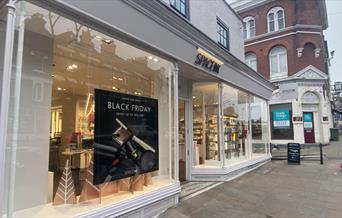 Outside Space NK in Blackheath. A stylish white and black shop front with a wonderful window display. In the display is decorations and some of the sh