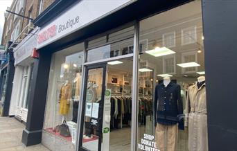 Outside Boutique by Shelter in Blackheath. A modern red, black and white charity shop. Inside is a wonderful selection of clothing.