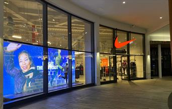 Outside Nike's Factory Store in Greenwich. Showing a stunning building with a huge selection of items.