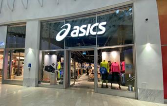 Outside Asics at The O2. A large building filled with stylish sports wear.