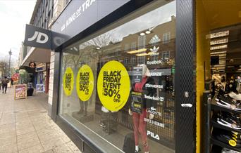 Outside JD Sports in Woolwich. A black, white and yellow themed shop with a great selection of items.