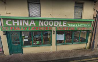 The outside of China Noodle Eltham, a green and red designed restaurant.