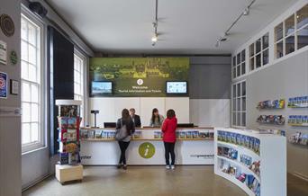 A photo of the Greenwich Tourism Centre, featuring a room filled with tourism leaflets and books. As well as an information desk.