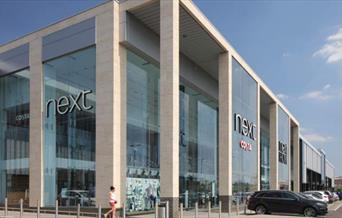 Next in Charlton, showing a tall modern building next to a car park.