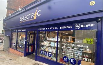 Outside Selectric in Blackheath, showing a blue and yellow shopfront with a range of products inside.