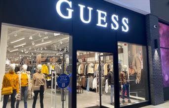 Outside Guess at The O2. A modern shop with a black and white design and a huge selection of products inside.