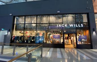 Outside Jack Wills at The O2. A stunning and modern building with a white Jack Wills logo at the front. Inside the shop is a huge selection of product