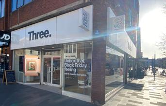 Outside Three in Eltham. A Sleek looking shop with a white design and a black logo.