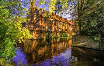 Looking over the moat, at the beautiful Tudor Barn on a sunny day