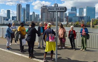 A group of people join a BSL Guided Tour beside Thomson and Craighead's 'Here' (2013) artwork