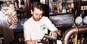 A barman making a drink at a restaurant called the Ship in Greenwich.