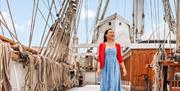 A lady stands on the upper deck of Cutty Sark in Greenwich, London.