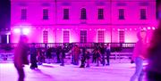 An illuminated ice rink in Greenwich in front of Queen's House.