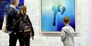 Family observing Carolina Kollmann Studio work 'INTO THE BLUE'