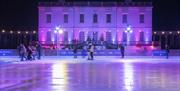 People skating at night at the Queen's House Ice Rink