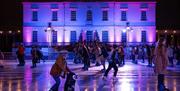 People skating at night at the Queen's House Ice Rink