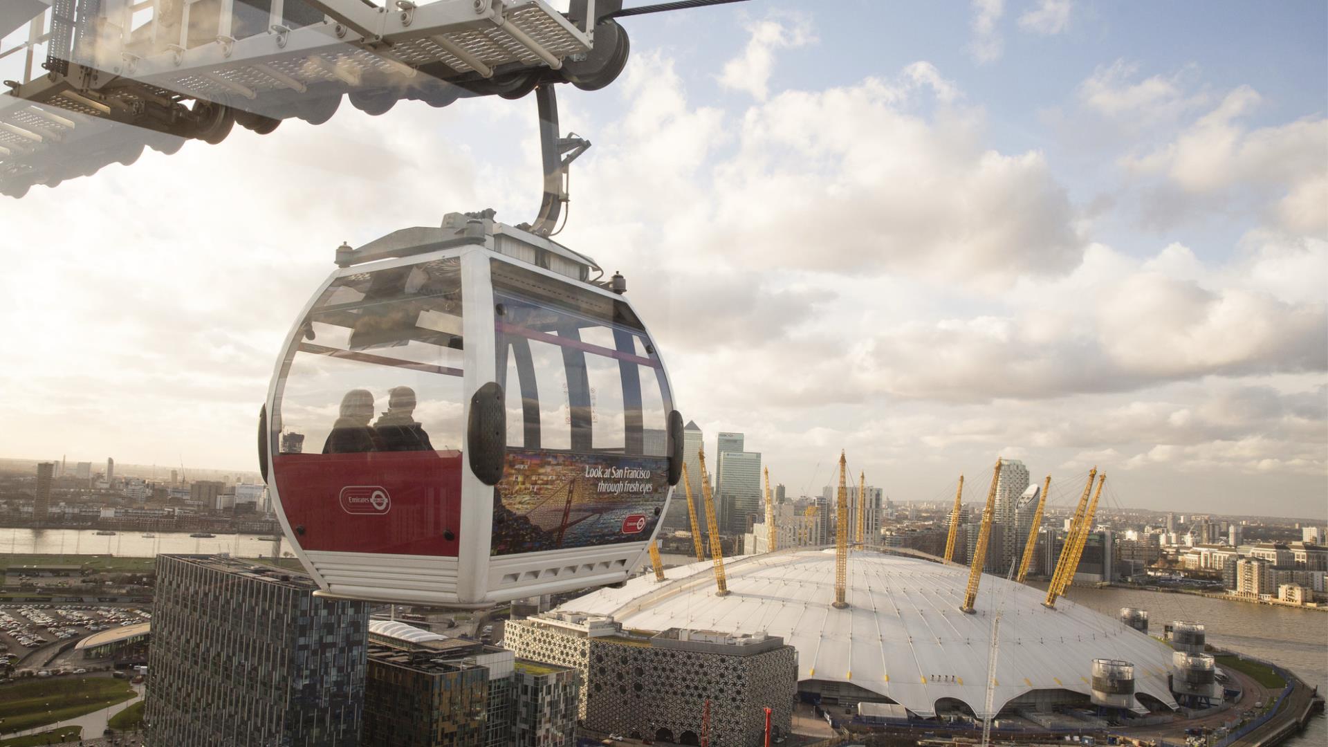 The Emirates Air Line glides through the sky above The O2 and Greenwich Peninsula.