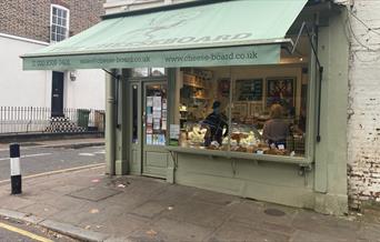 Outside The Cheeseboard in Greenwich. A green shop with a huge selection of mouth-watering food.