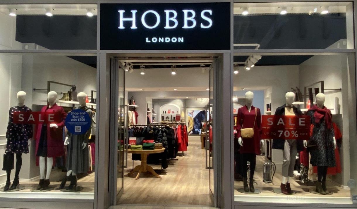Outside Hobbs at The O2. A modern shop with multiple windows that show a huge selection of clothing and accessories.