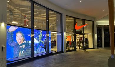 Outside Nike's Factory Store in Greenwich. Showing a stunning building with a huge selection of items.