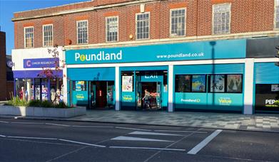 Outside Poundland in Eltham. The picture shows a large turquoise building with a wide range of products.