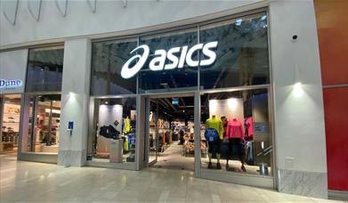 Outside Asics at The O2. A large building filled with stylish sports wear.