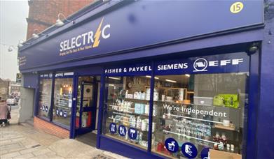 Outside Selectric in Blackheath, showing a blue and yellow shopfront with a range of products inside.