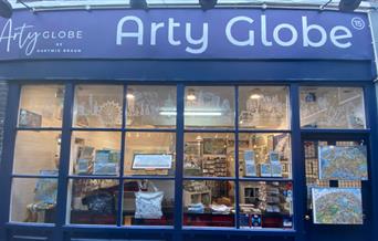 Outside Arty Globe in Greenwich. A blue and white shop front with a stunning artwork display inside the window.