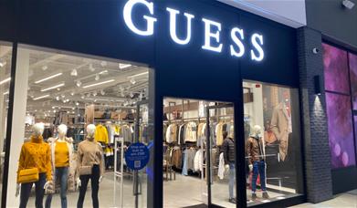 Outside Guess at The O2. A modern shop with a black and white design and a huge selection of products inside.
