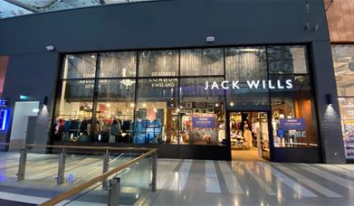 Outside Jack Wills at The O2. A stunning and modern building with a white Jack Wills logo at the front. Inside the shop is a huge selection of product