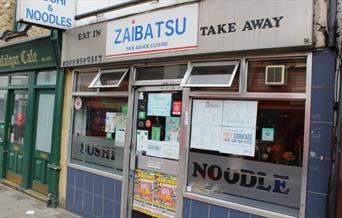 Image showing the entrance of Zaibatsu Japanese Fusion Restaurant with menu displayed on the glass window.
