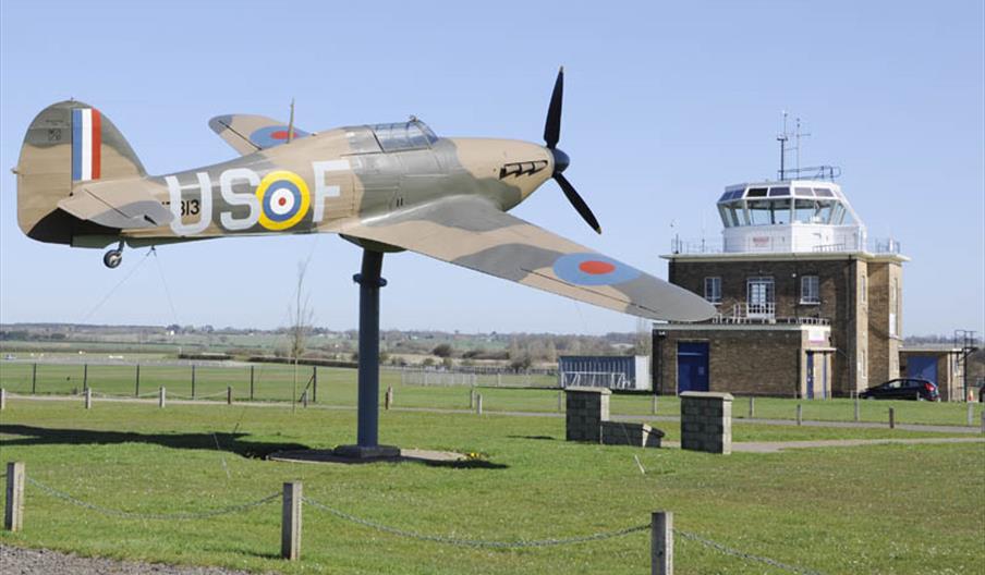 The Hurricane "Gate-Guardian" at North Weald Airfield with control tower in the background.