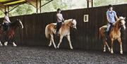 Learning to ride at High Beech Riding School, Epping Forest.