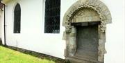 Norman arch over disused doorway in the wall at Lambourne Church.