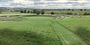 The earthwork sculpture at Theydon Bois seen from the top of the hill with M11 on the left and new woodland beyond the sculpture.