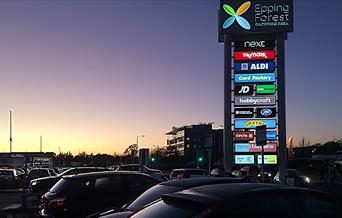 Epping Forest Shopping Park at dusk.