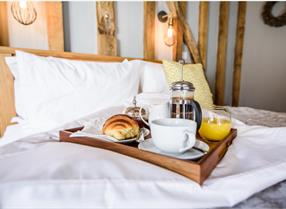 Coffee and breakfast on the bed at a hotel