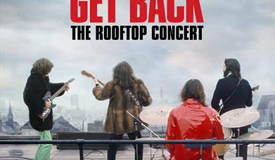 Image of The Beatles on a roof top playing guitar and drums