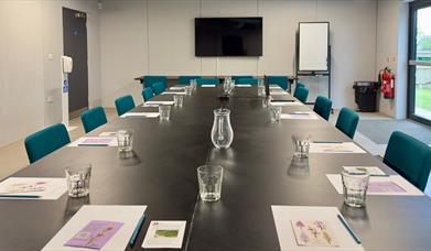 Photograph of a meeting room set up in a boardroom style.