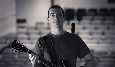 Chris Allard holding a guitar
