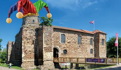 A picture of Colchester Castle with a Jester's hat superimposed on one of the towers