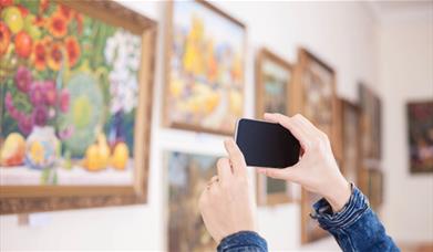 Person taking photos at an art exhibition