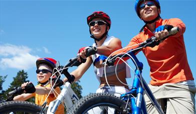 A child and two adults riding on bicycles