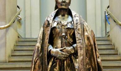 Living bronze statute of Queen Victoria in front of steps.