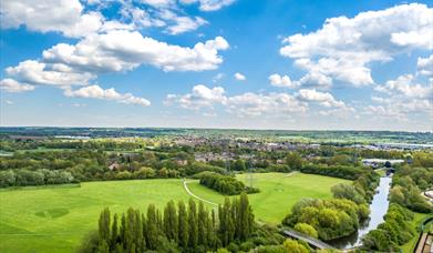 Aerial view of the showground site in River Lee Country Park showing large grass areas, tree and canal.