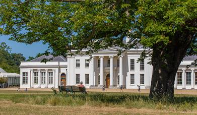 The exterior of Hylands House with people enjoying the front lawn. 