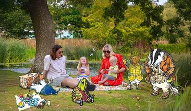 A Family having a picnic under the three in front of water.  Surrounded by the characters from Wind in the Willows