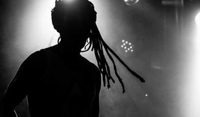 A silhouette of a man with dreadlocks