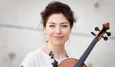 A female musician poses with her violin