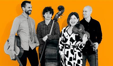 A jazz band pose with guitars, double bass and violin.